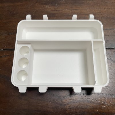 A white 3D-printed tray with a large compartment, a narrow side slot and three round wells.
