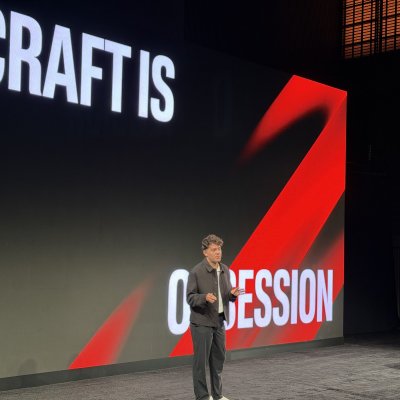 A speaker on stage in front of a massive slide that reads “Craft is obsession.”